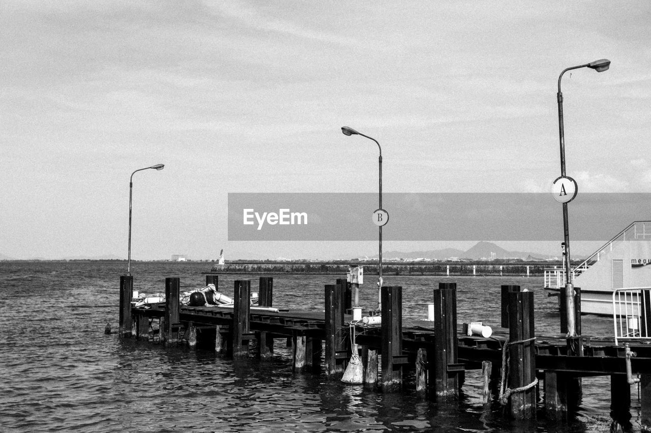 WOODEN PIER ON SEA AGAINST SKY