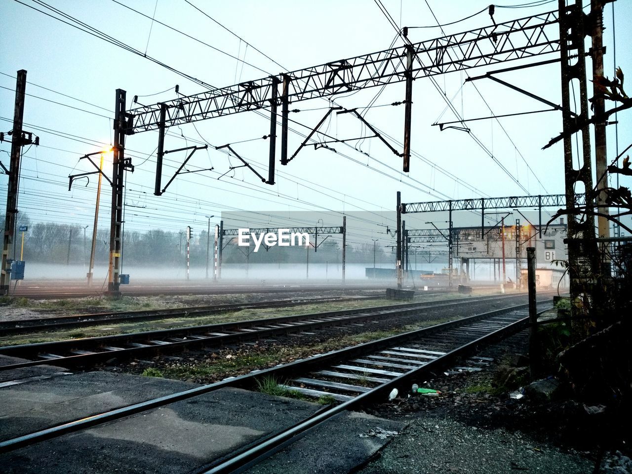 Railroad tracks against sky during morning mist