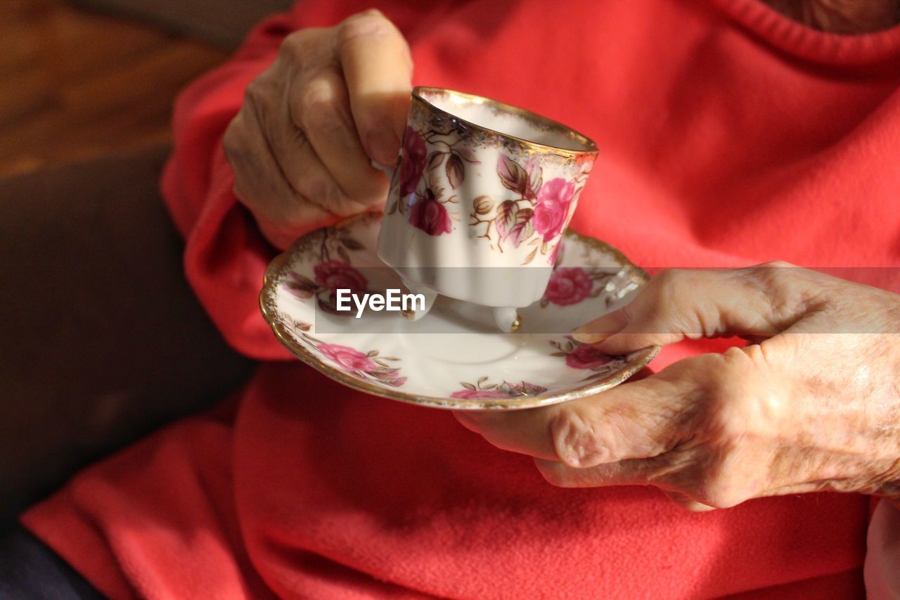 Midsection of woman holding coffee cup