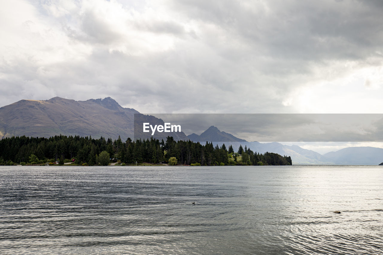 Scenic view of lake by mountains against sky