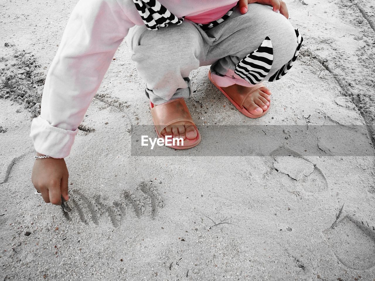 Low section of person crouching at beach