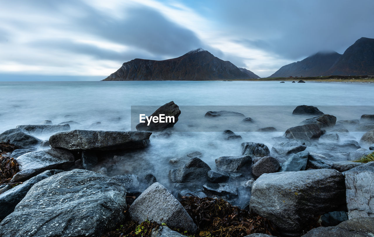 Scenic view of sea and mountain against clear sky