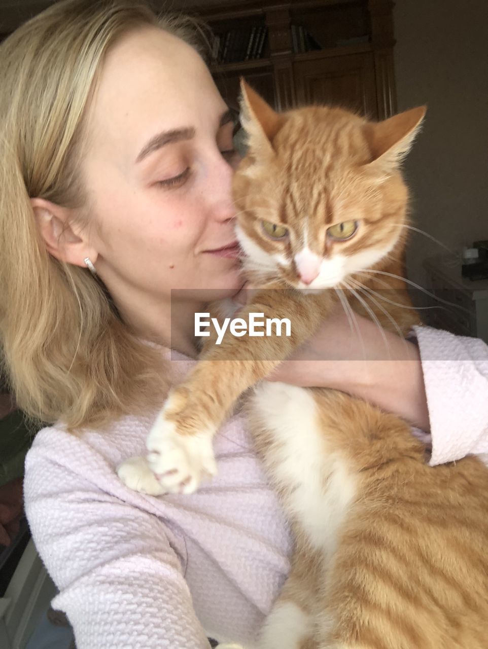 PORTRAIT OF CAT WITH BABY ON BED