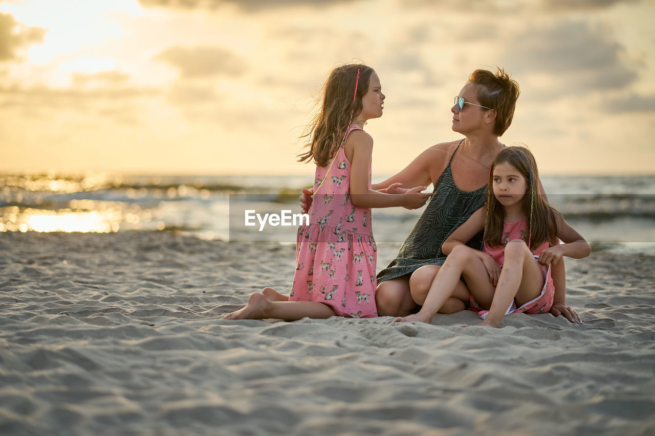 Rear view of women sitting on beach