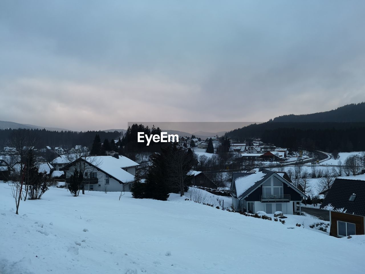 SNOW COVERED BUILDINGS ON MOUNTAIN AGAINST SKY