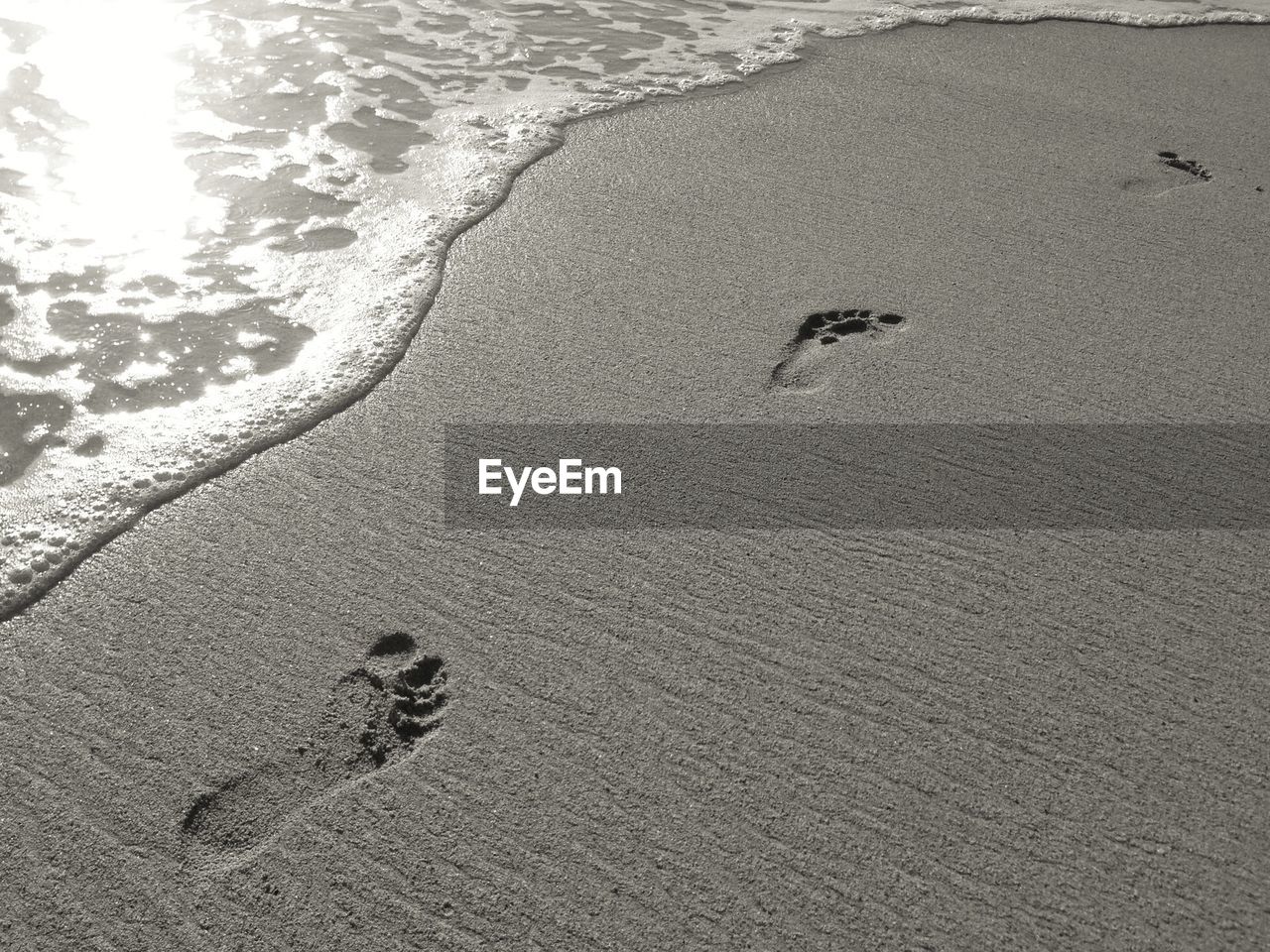 Close-up of footprints on sand at beach