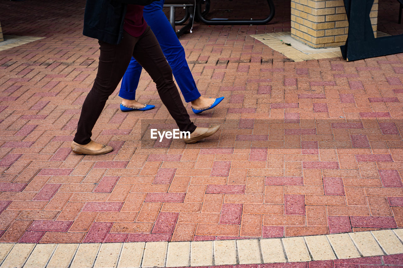 Low section of people walking on sidewalk