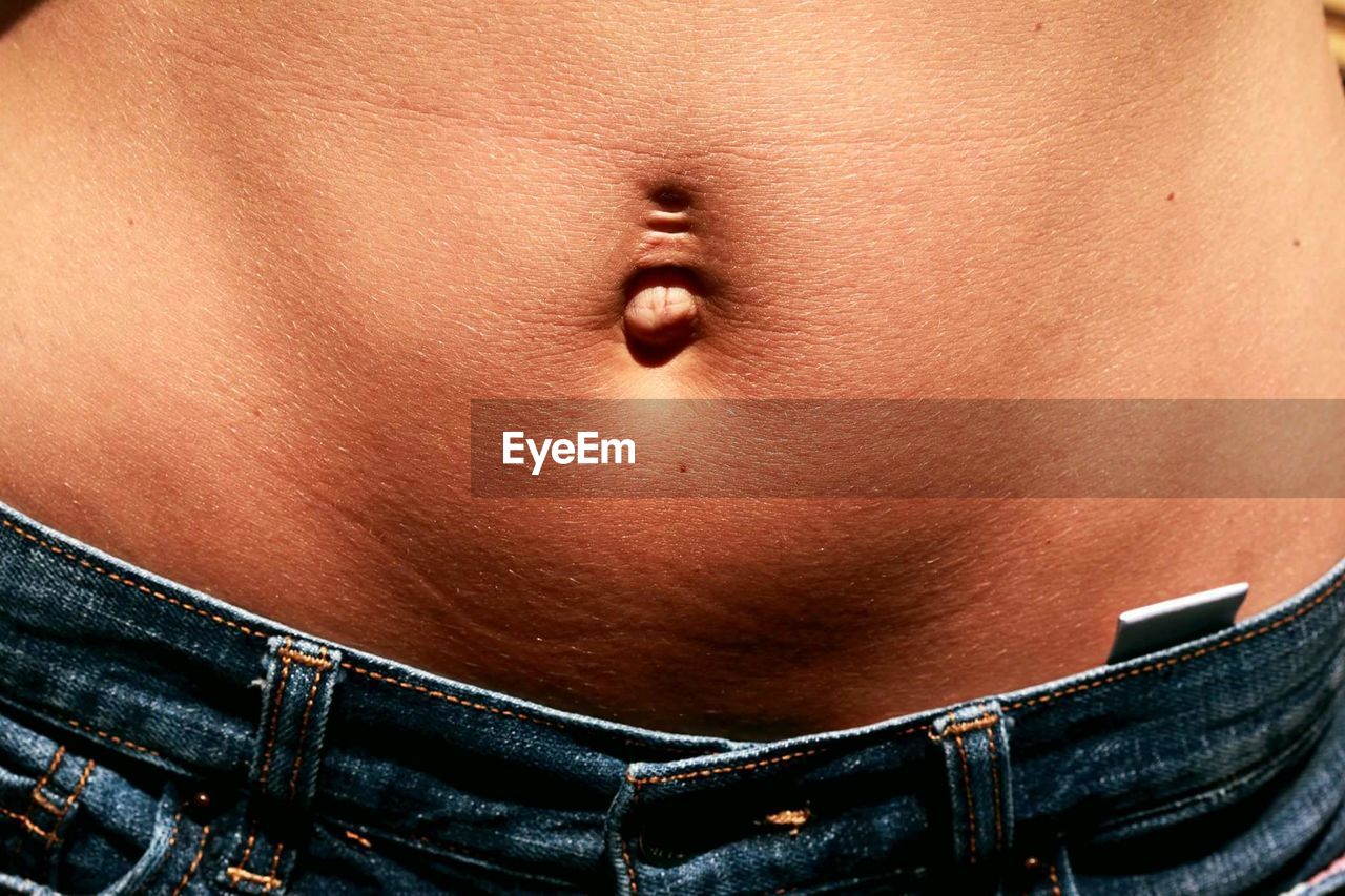 Close-up midsection of pierced belly button