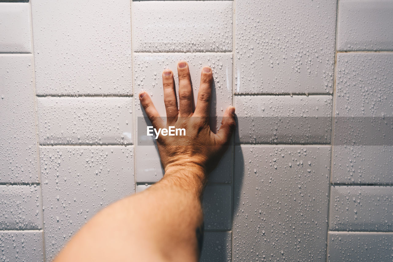 Close-up of hand on wet wall