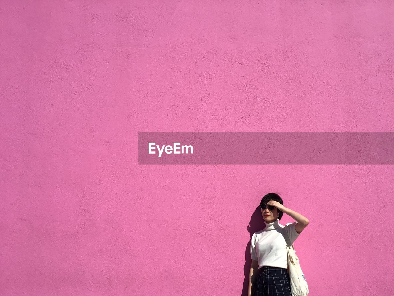 Woman by a pink wall