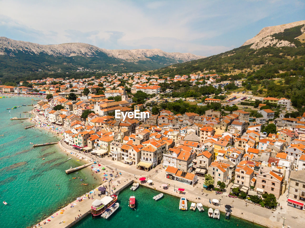 High angle view of townscape by sea against sky