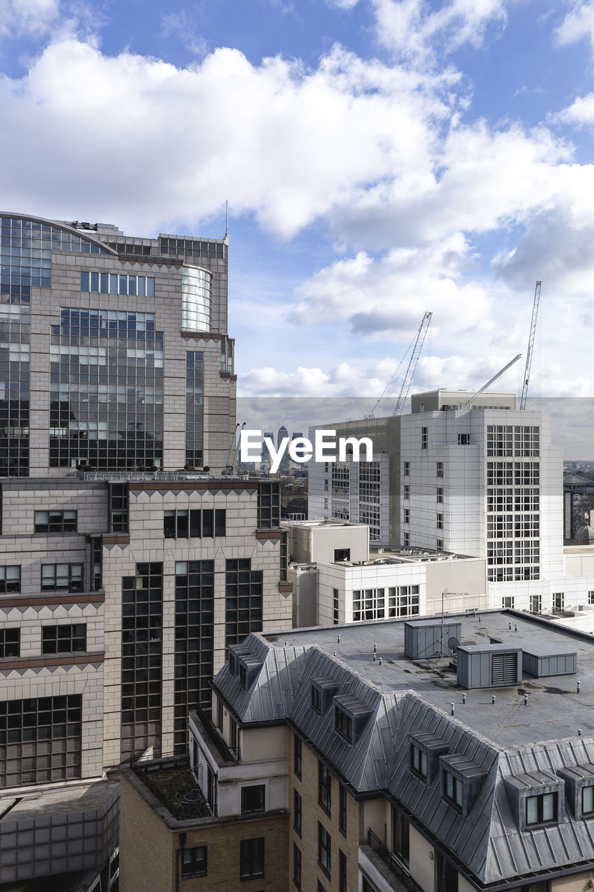 Buildings in city against cloudy sky