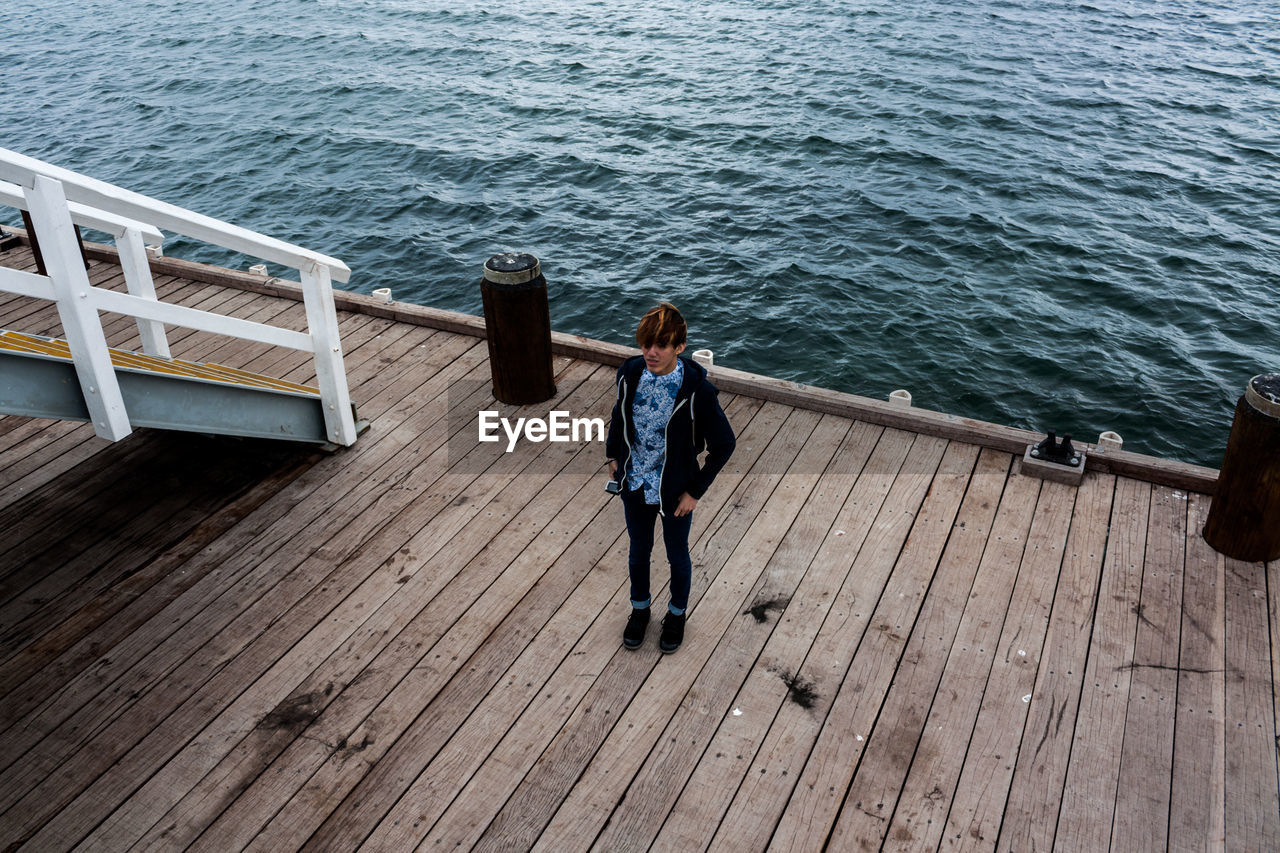 High angle view of teenager standing at busselton jetty