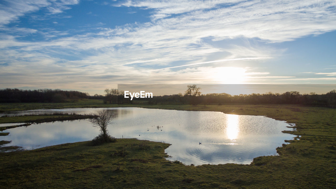 Scenic view of lake against sky at sunset