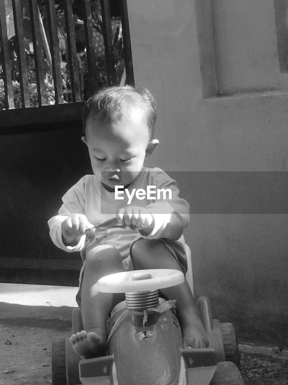 FULL LENGTH OF CUTE BABY BOY SITTING OUTDOORS