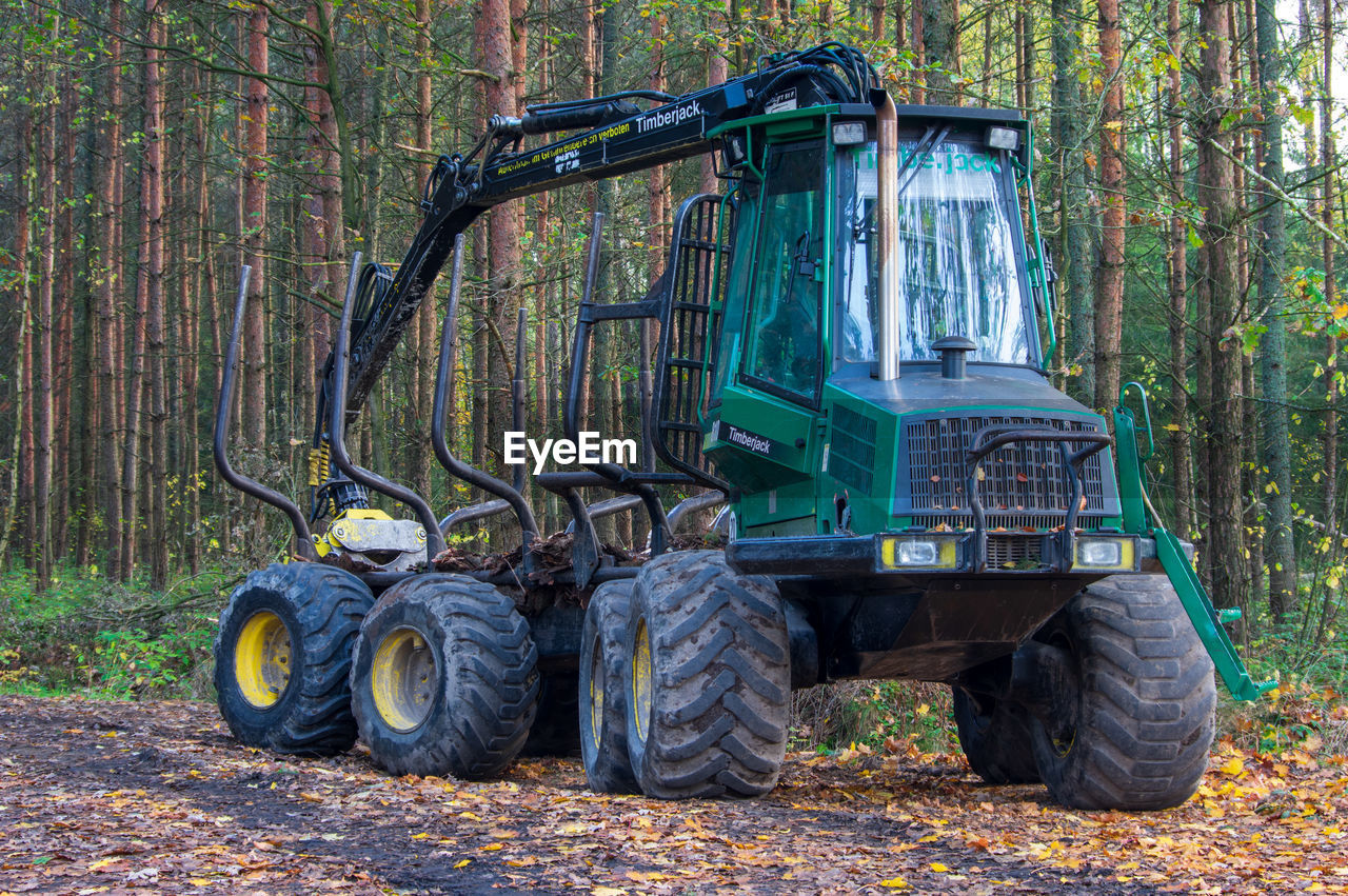 OLD TRACTOR ON FIELD AGAINST TREES