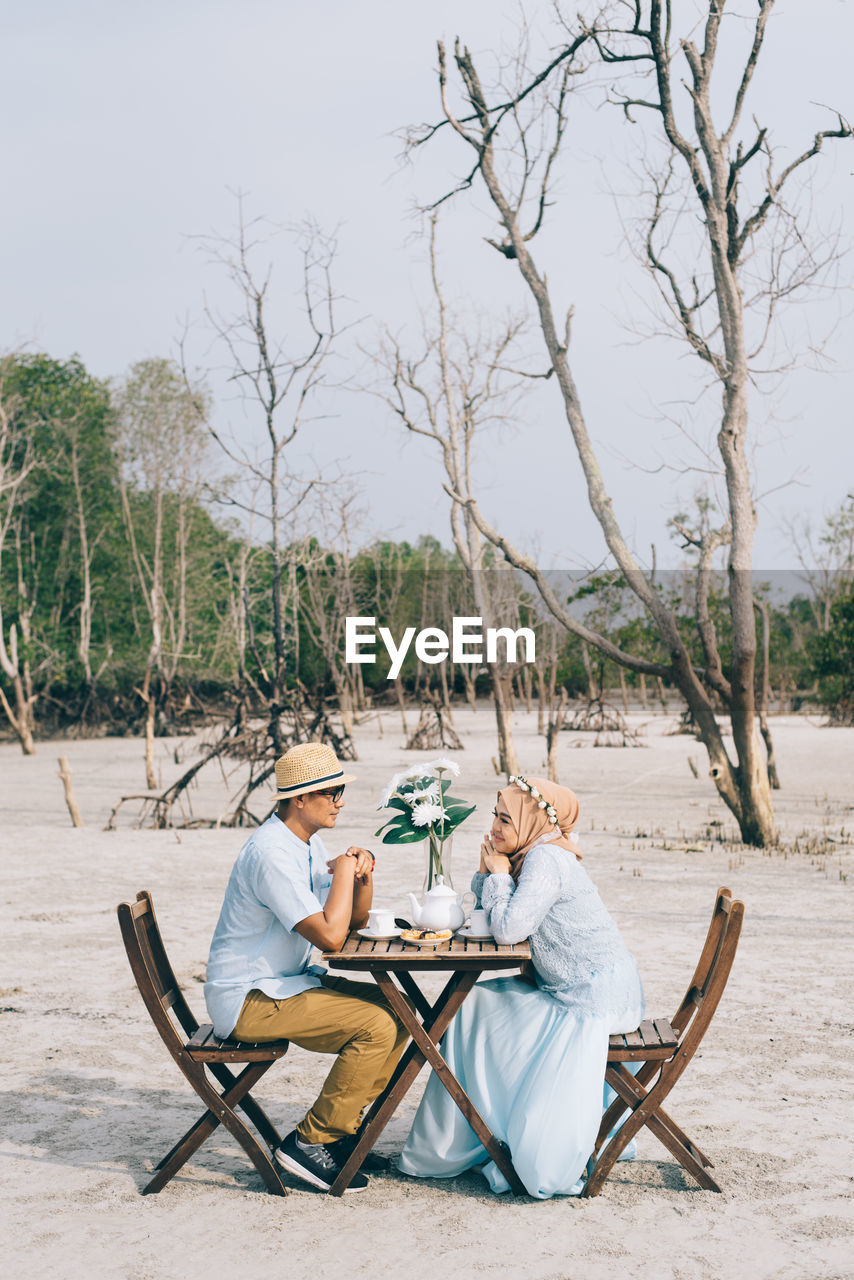 Couple at date against bare trees