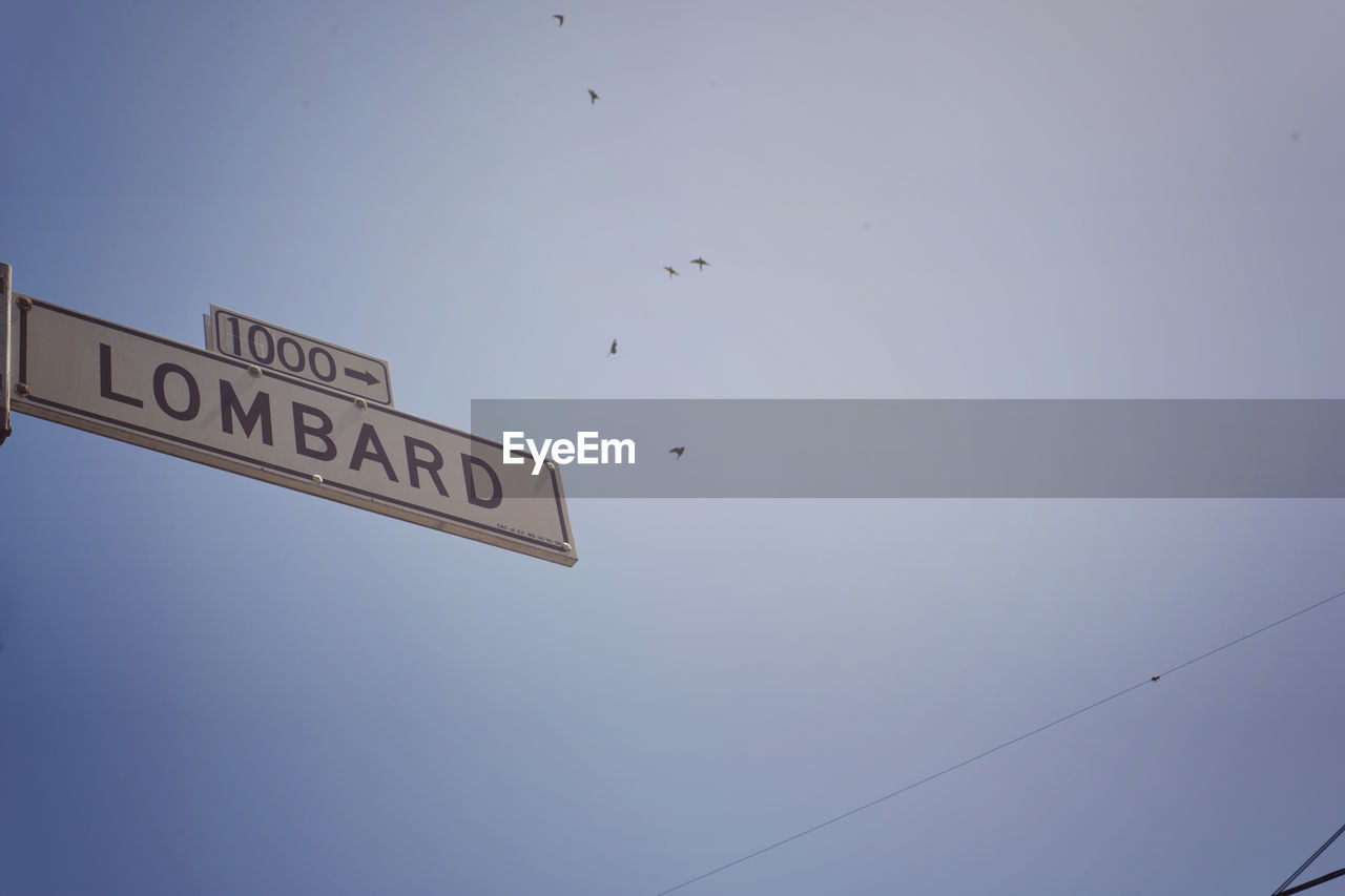 Low angle view of road sign against clear sky