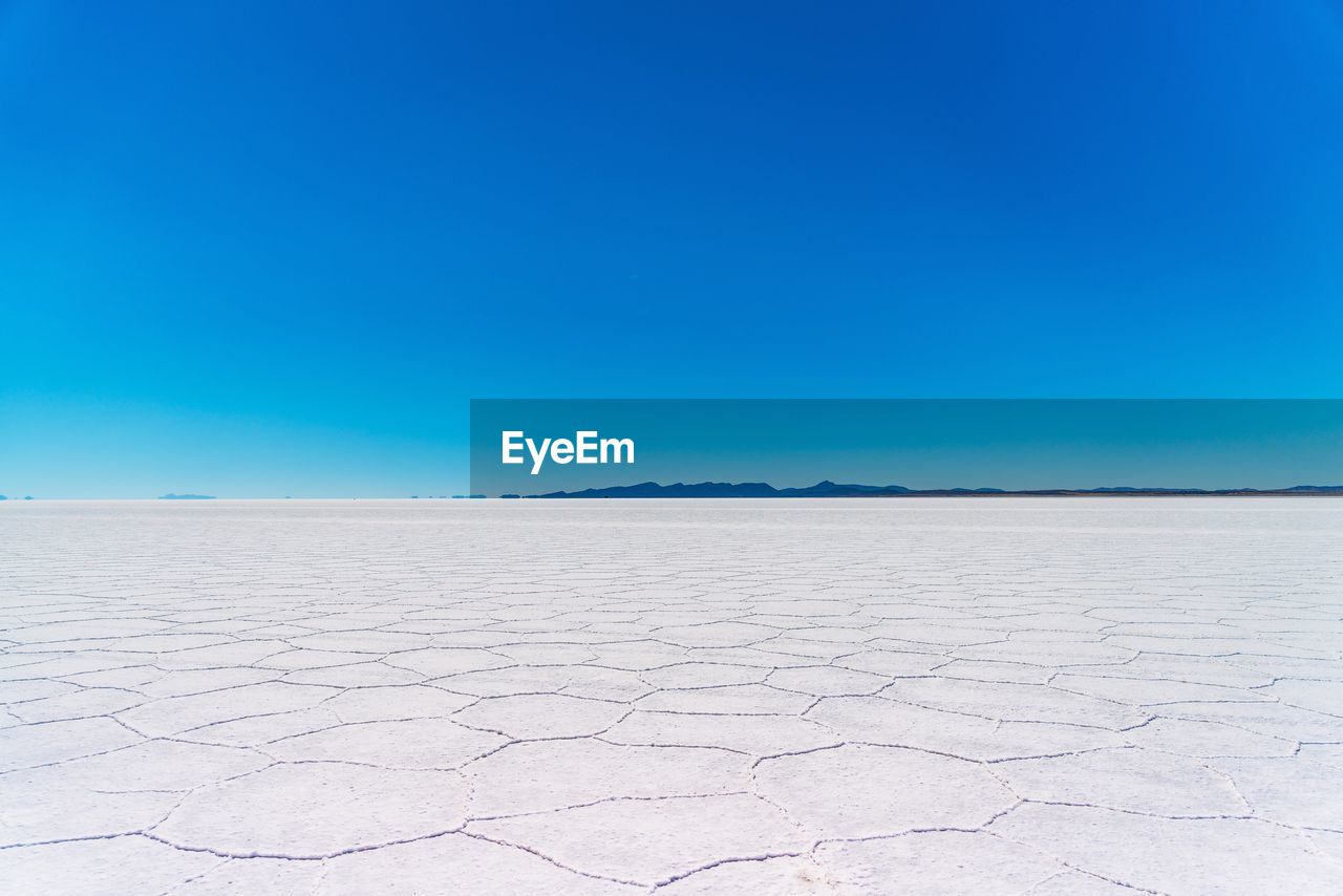 Scenic view of desert against clear blue sky