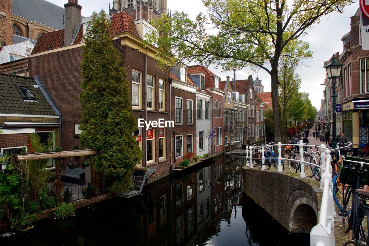 CANAL AMIDST BUILDINGS AND TREES IN CITY