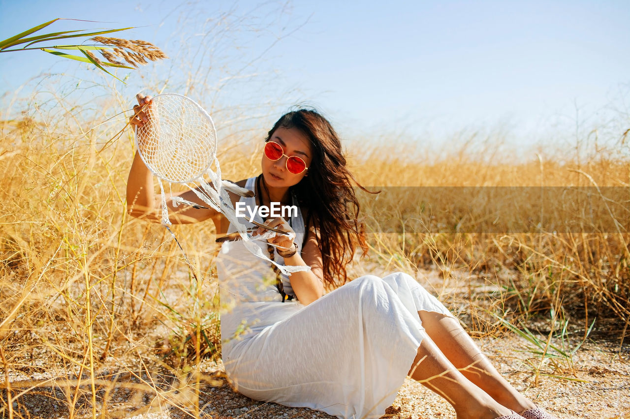 Young woman in field with dry grass