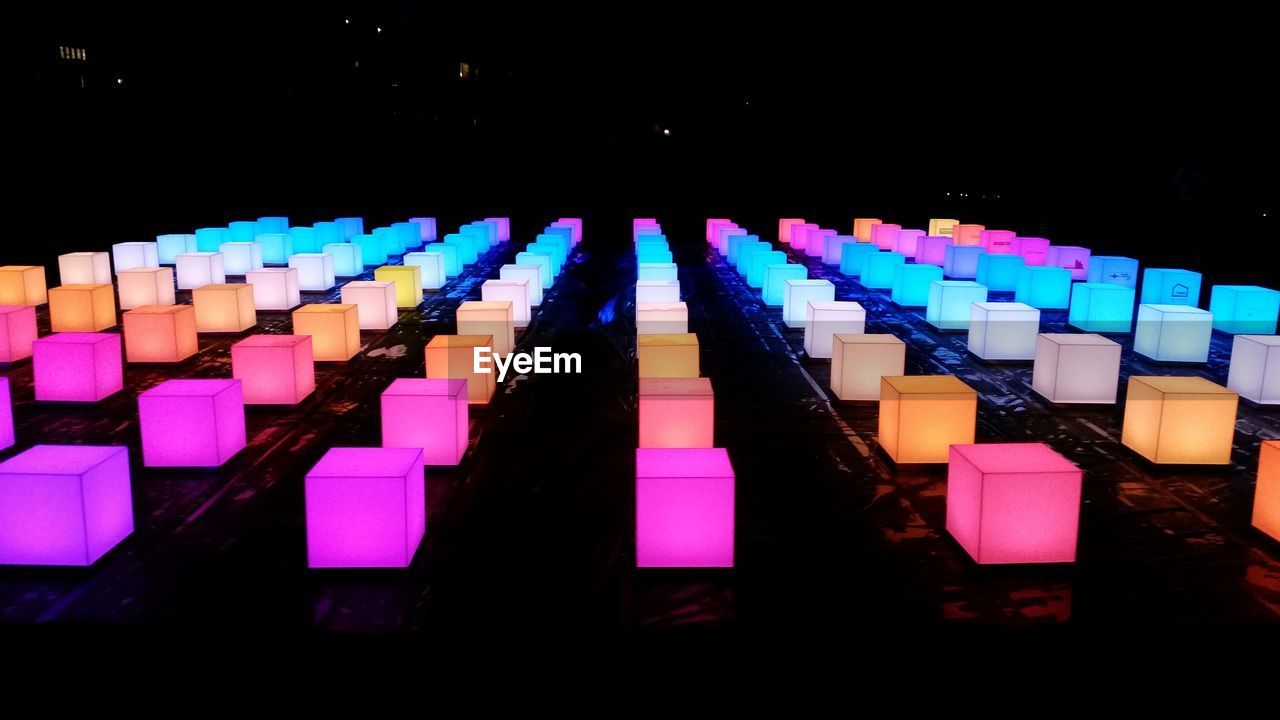 CLOSE-UP OF MULTI COLORED PENCILS IN ROW AT NIGHT