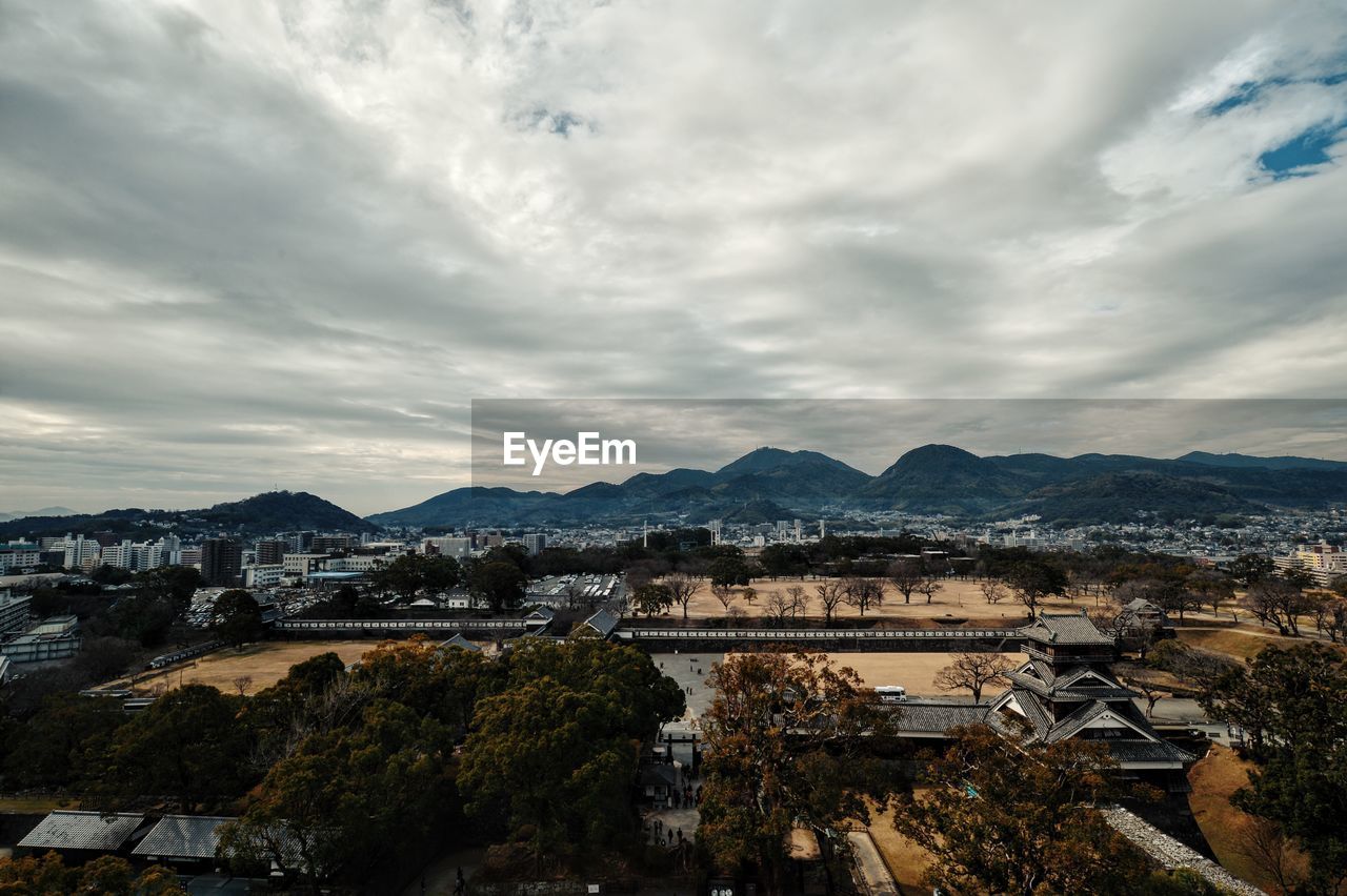 Kumamoto castle with cityscape against cloudy sky