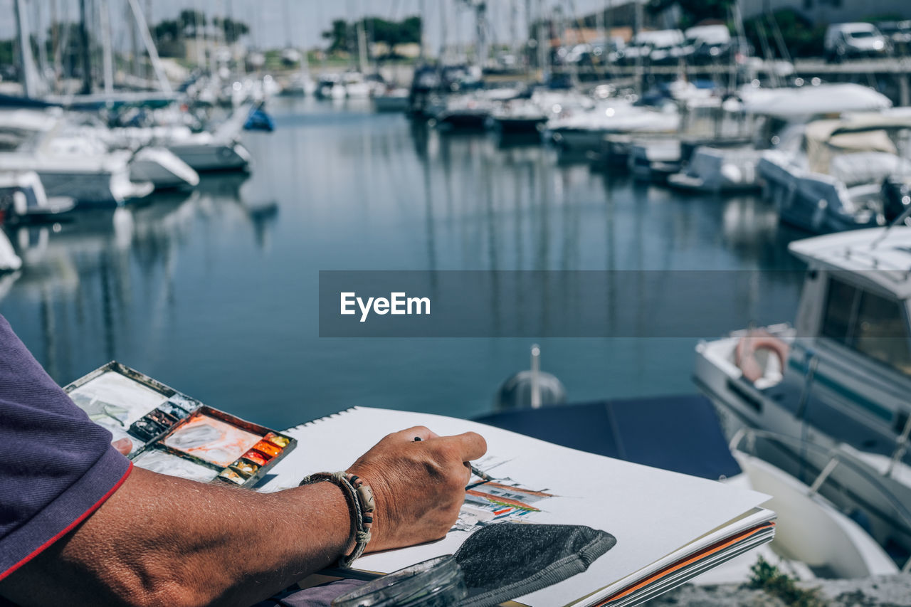 Cropped image of man painting harbor