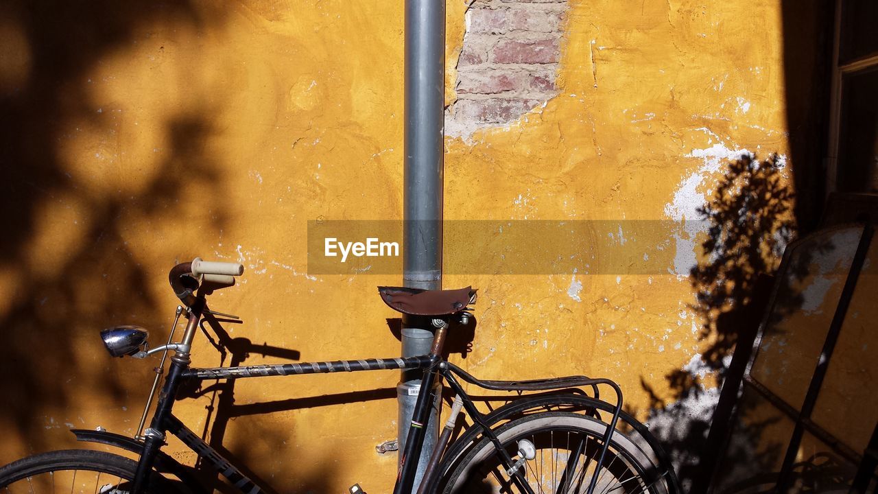 CLOSE-UP OF BICYCLE PARKED AGAINST WINDOW