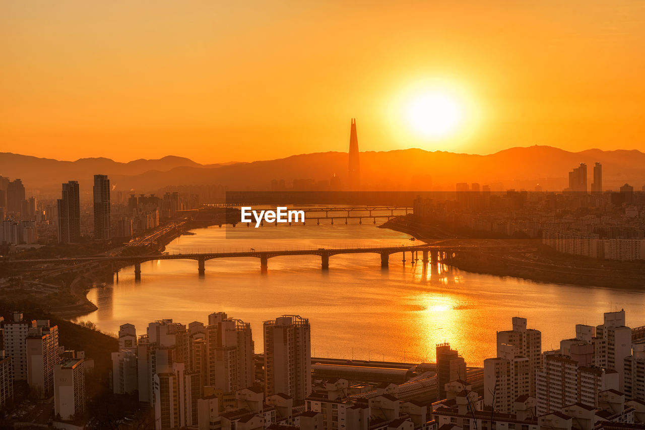 View of city at waterfront during sunset