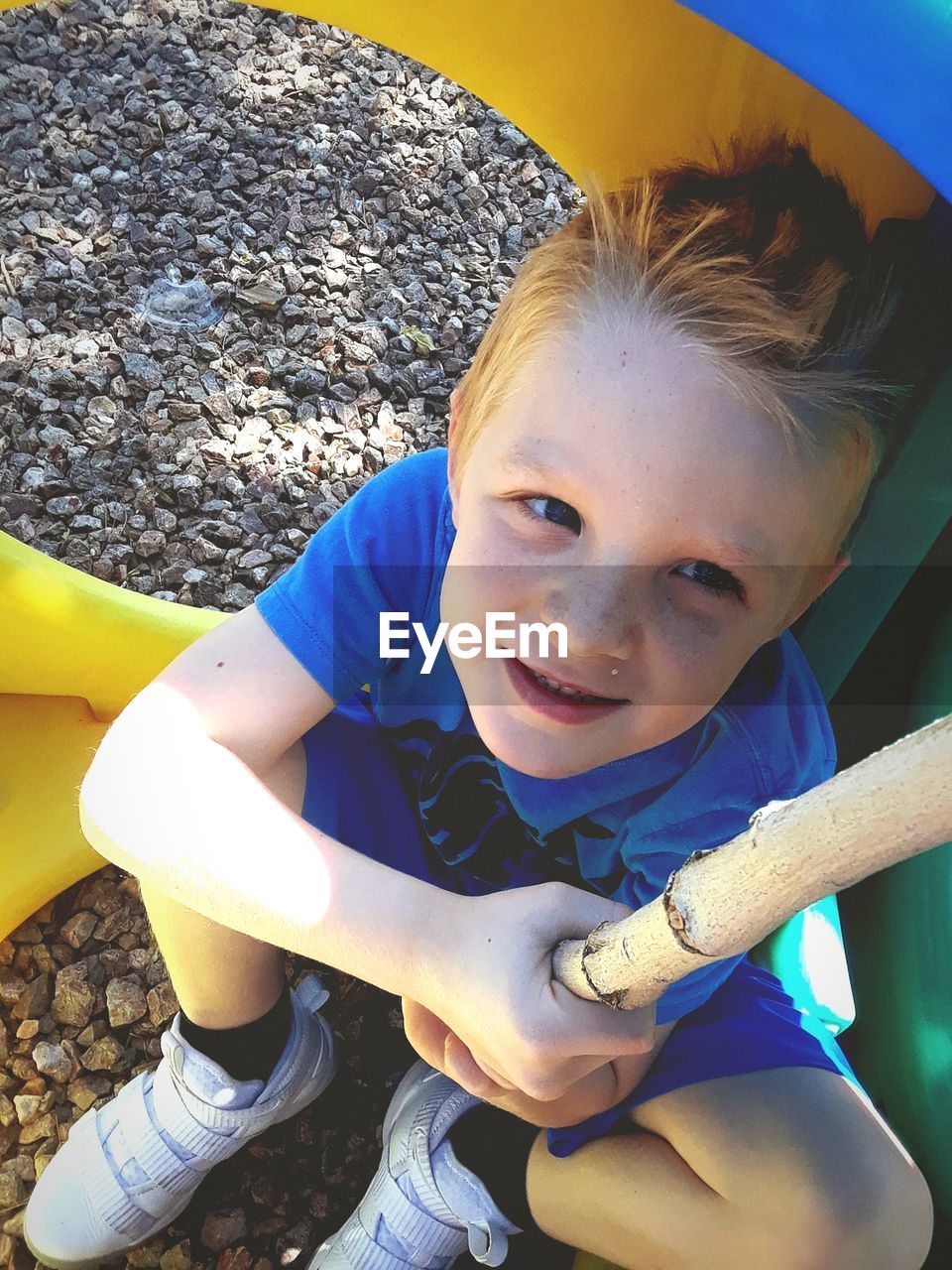 High angle view of boy sitting at playground