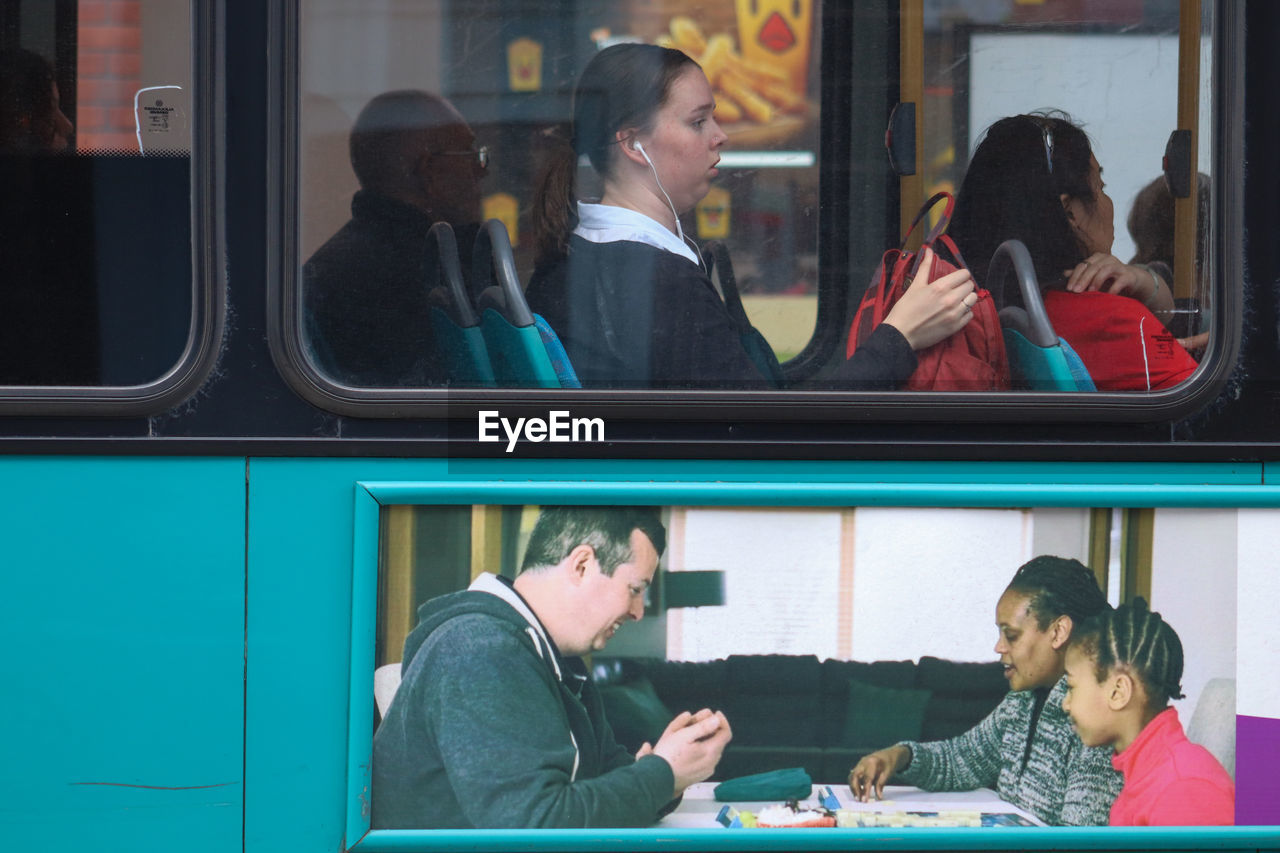 PEOPLE SITTING IN TRAIN AT WINDOW