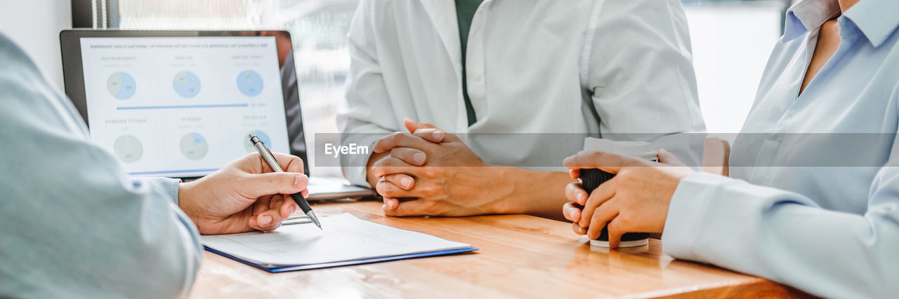 midsection of doctor examining patient at clinic