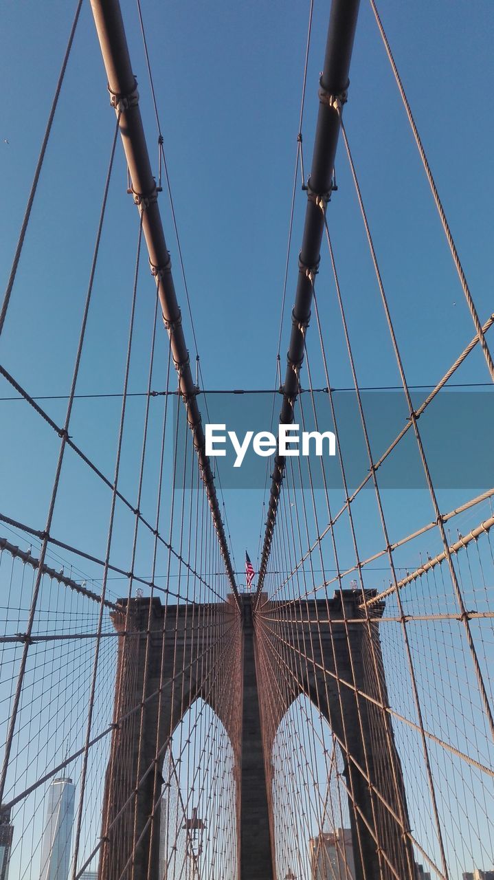 Low angle view of brooklyn bridge against clear blue sky