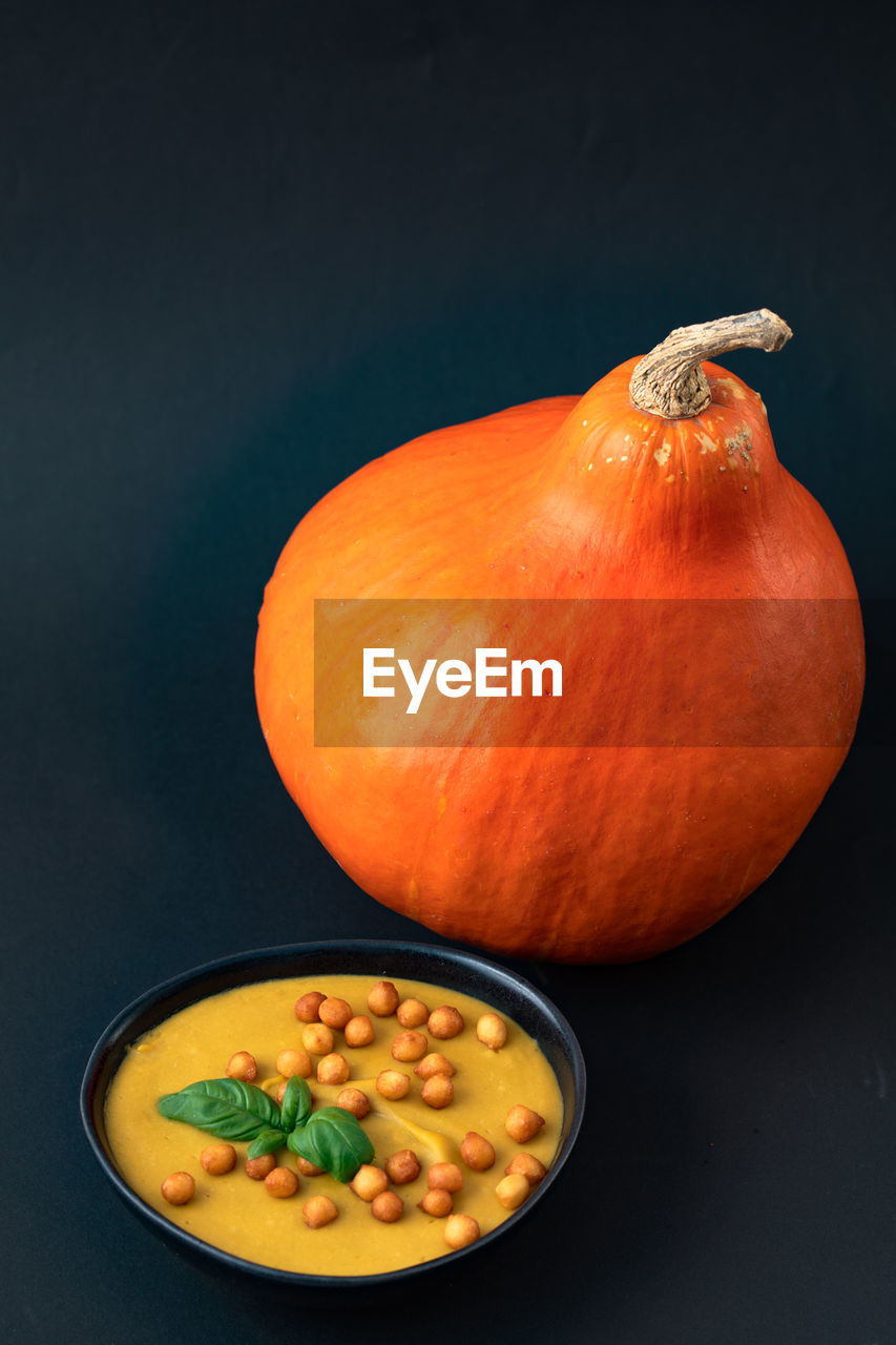 High angle view of pumpkin and bowl of soup on table