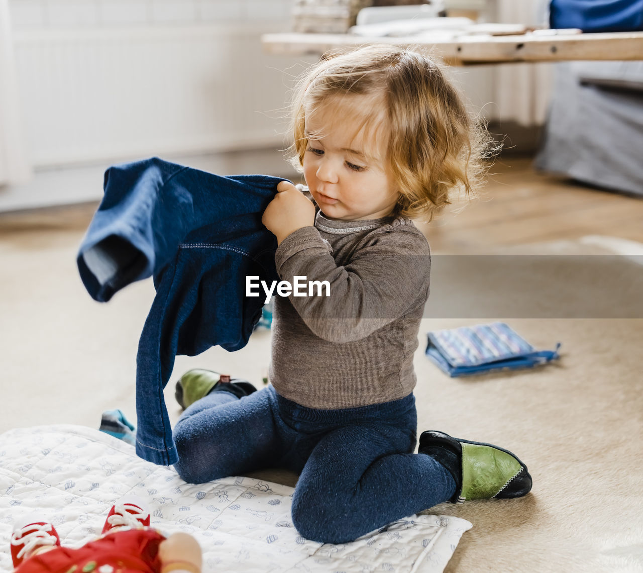 Baby girl wearing clothes at home