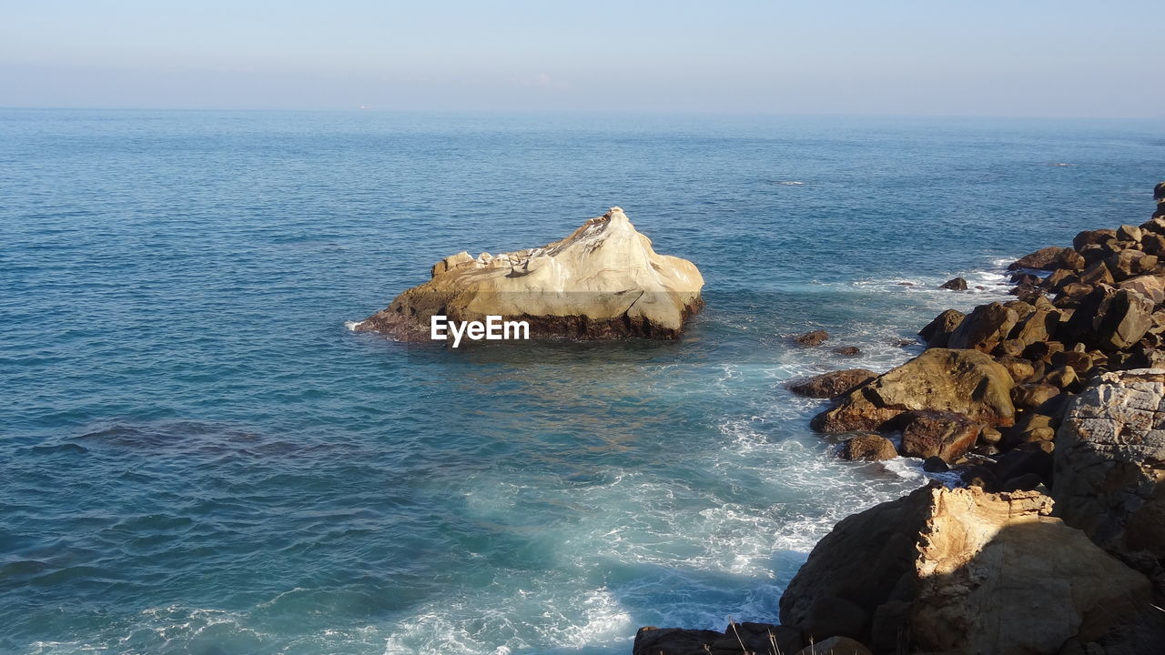 Rocks in sea against sky