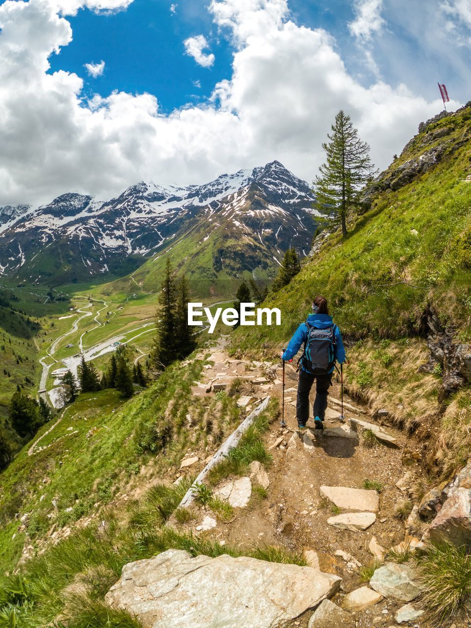 Woman hiking on footpath in the austrian alps near gastein, salzburg, austria