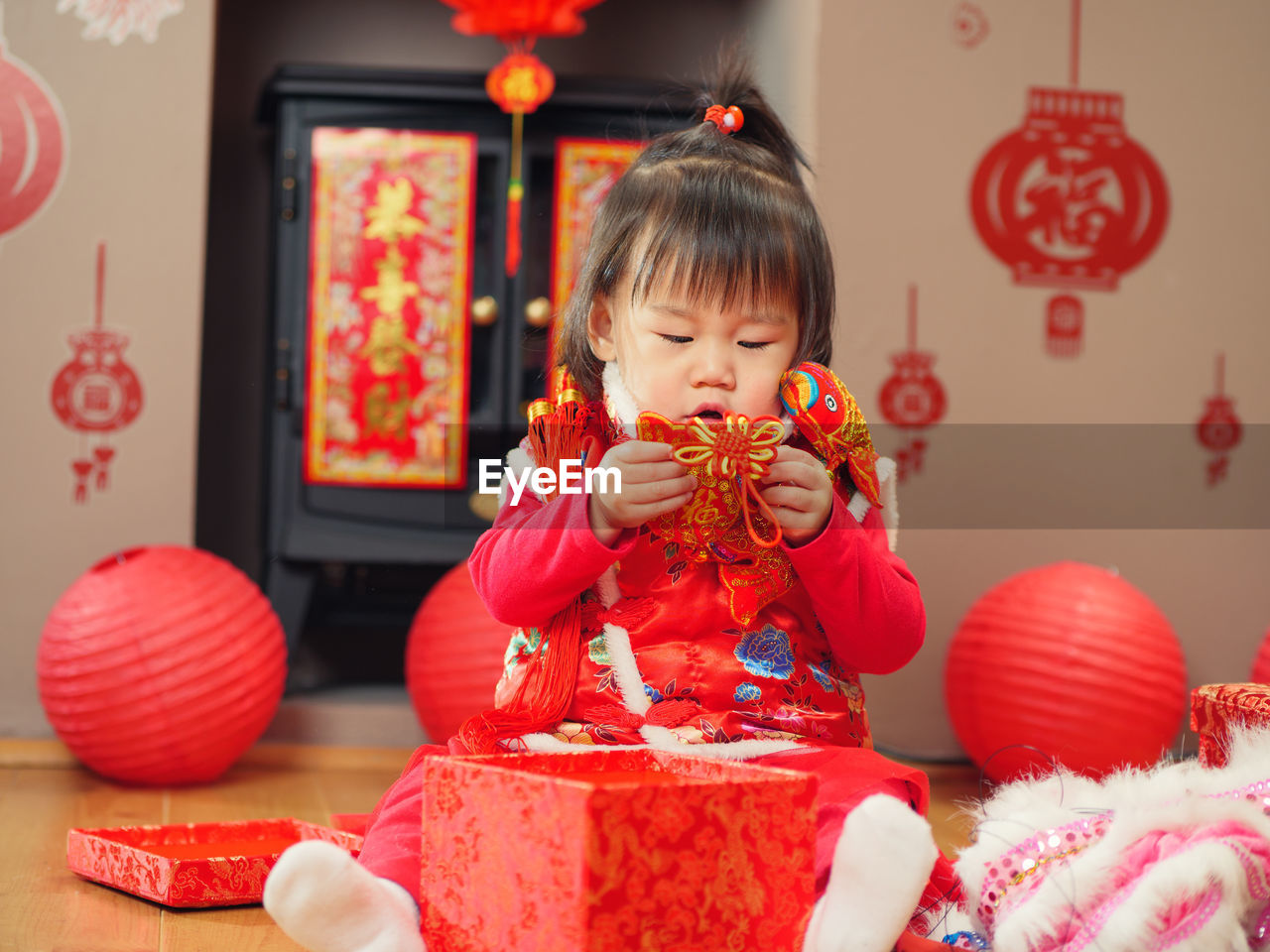 Cute girl in traditional clothing with decoration sitting at home