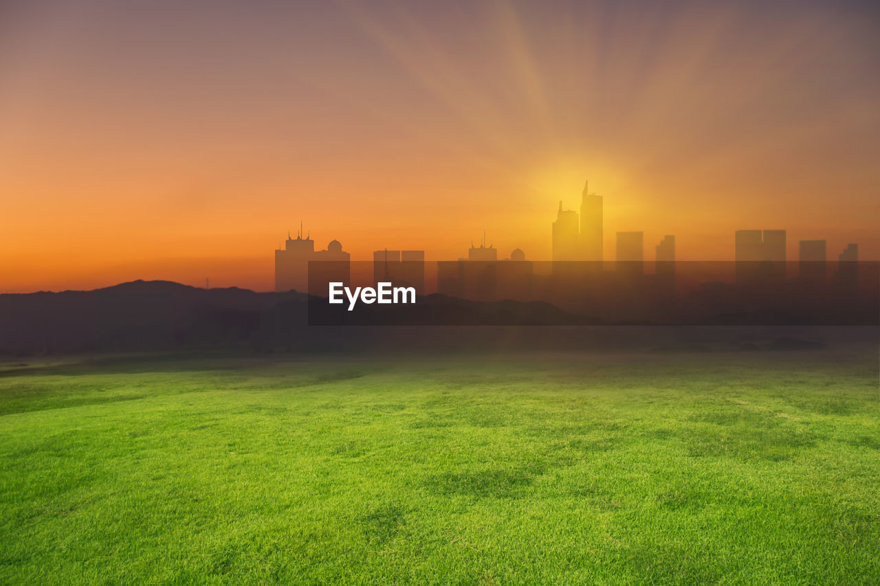 Digitally generated image of landscape by city during sunset