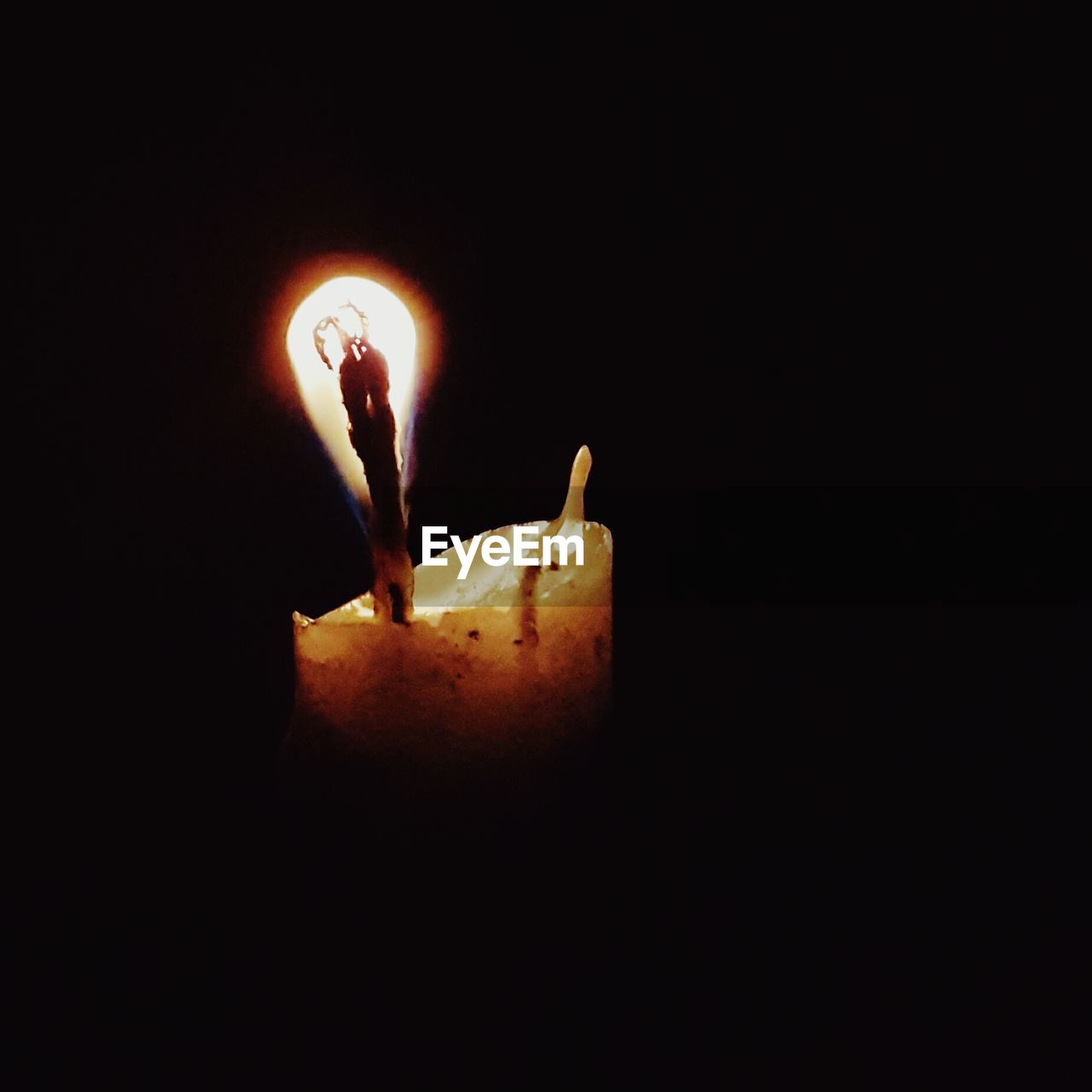 CLOSE-UP OF ILLUMINATED CANDLE