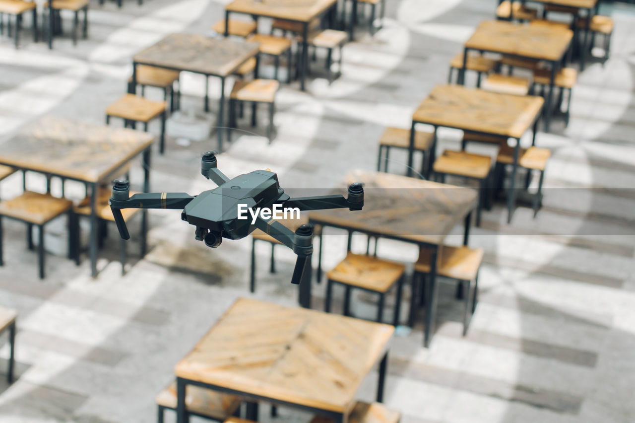 Close-up of drone over tables and chairs