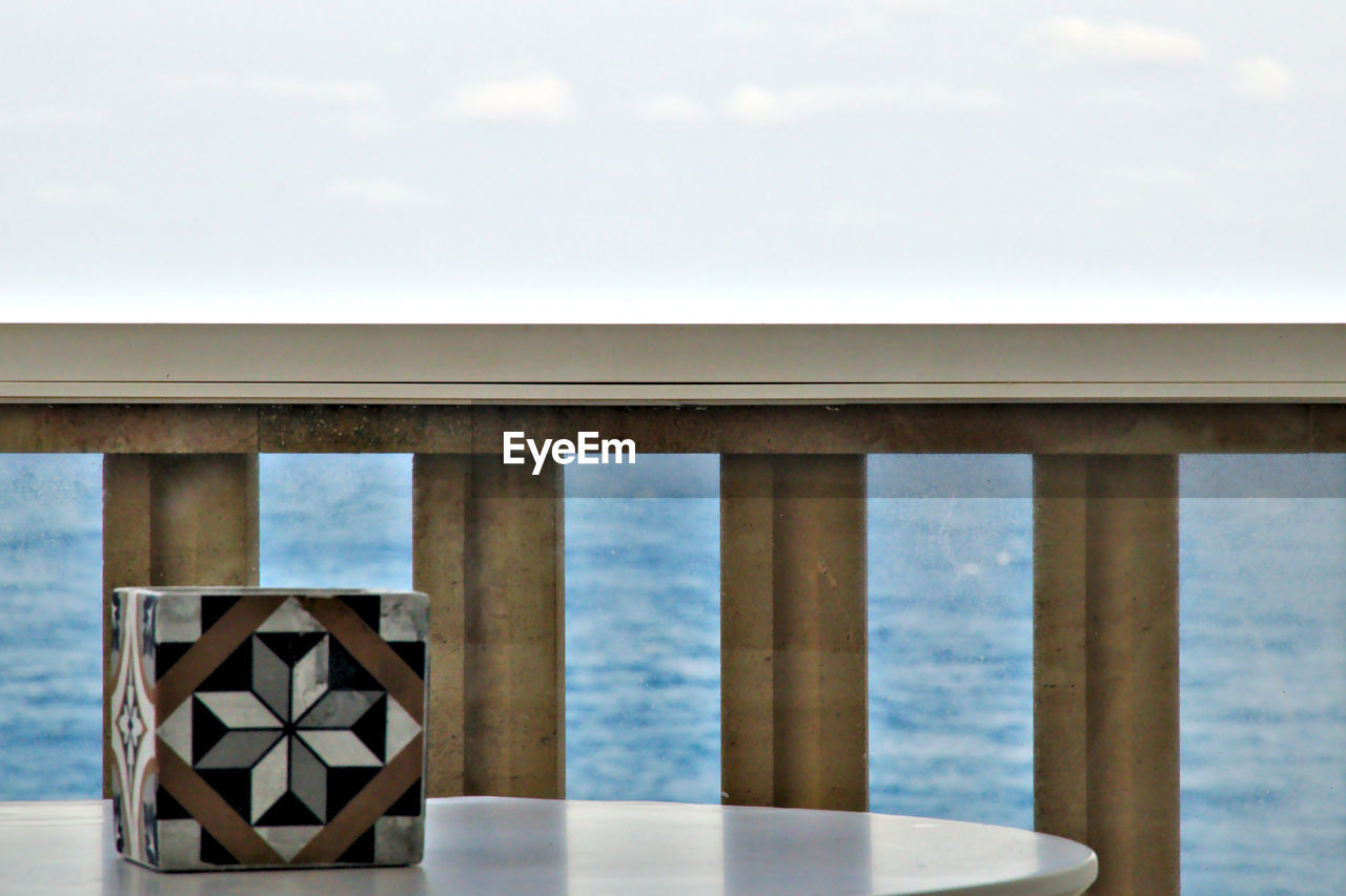 Close-up of table by sea against sky