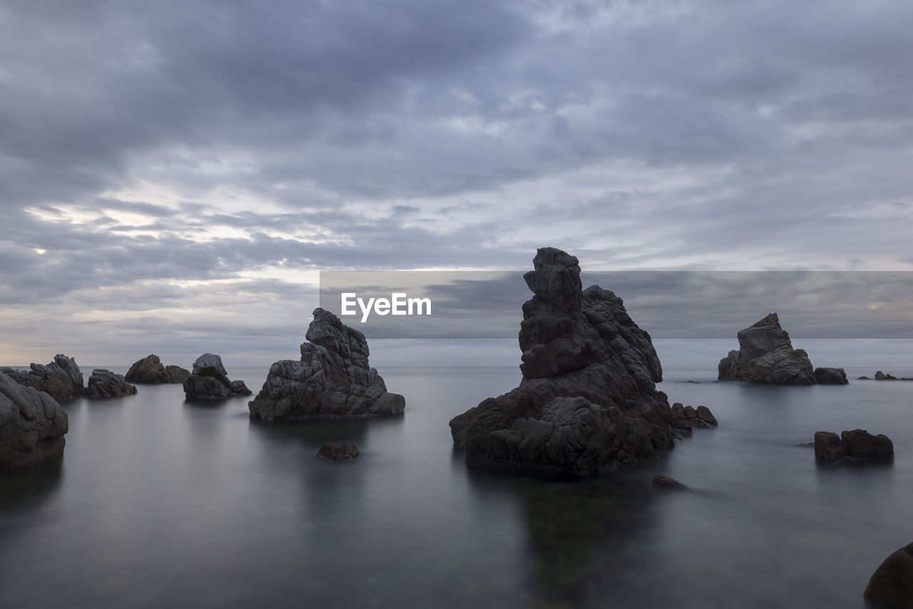 ROCK FORMATION IN SEA AGAINST SKY