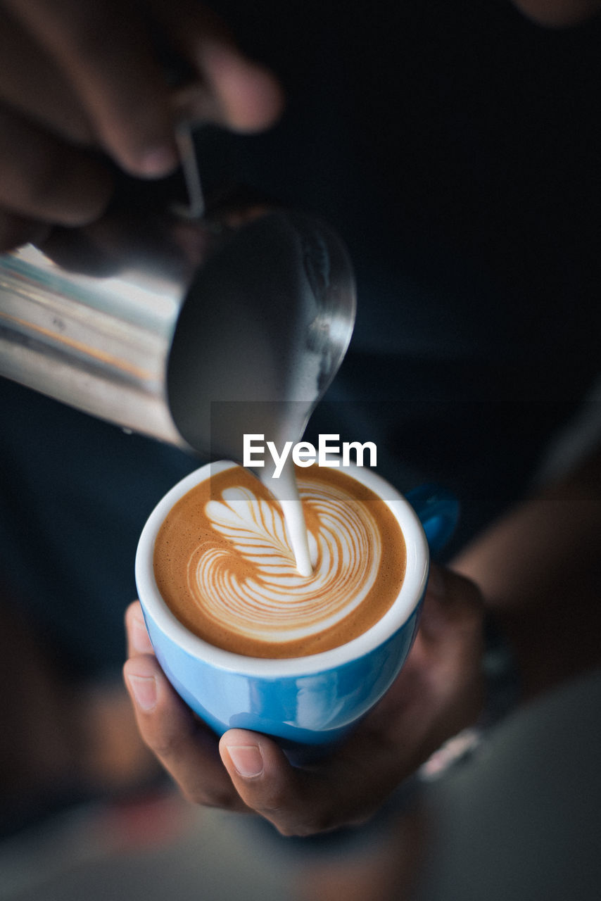 Midsection of man preparing coffee in cafe