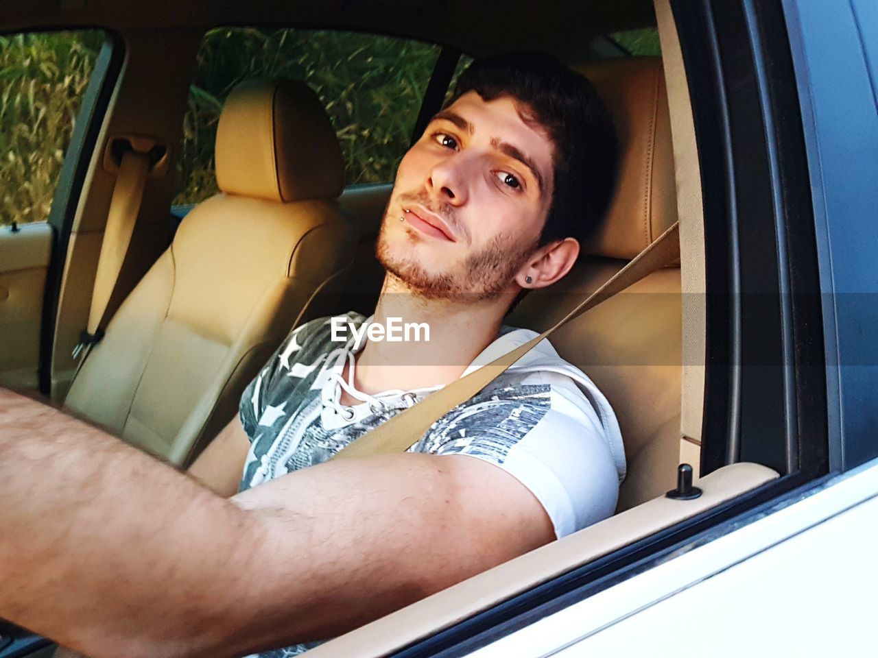 Portrait of young man sitting in car