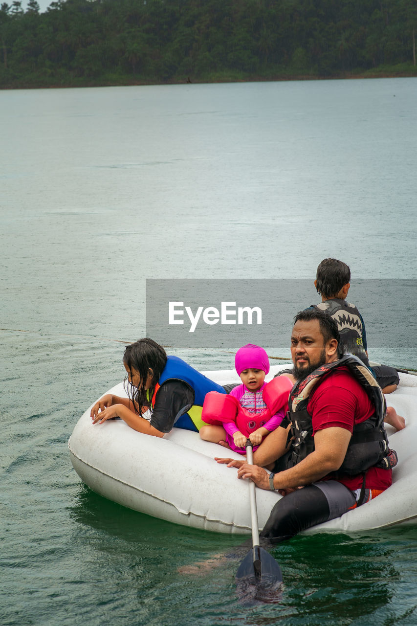 People sitting on boat in lake