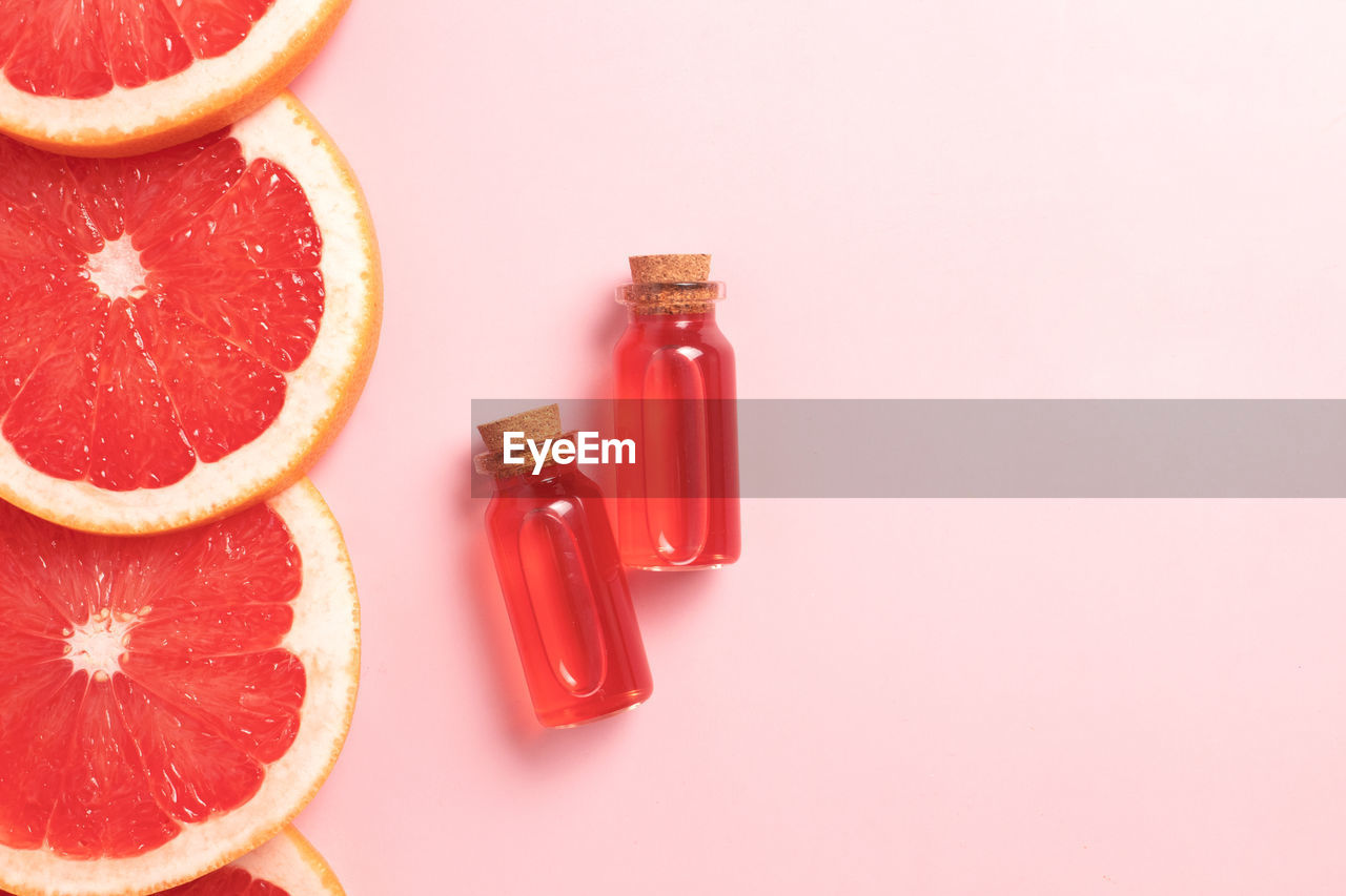 orange, grapefruit, food and drink, food, fruit, citrus fruit, healthy eating, wellbeing, studio shot, orange color, produce, blood orange, indoors, freshness, red, no people, plant, slice, citrus, soft drink, cross section, colored background, vitamin, container, still life, drink, high angle view, juice