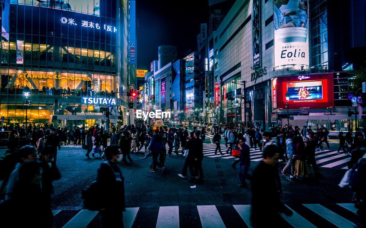 People on city street against buildings at night