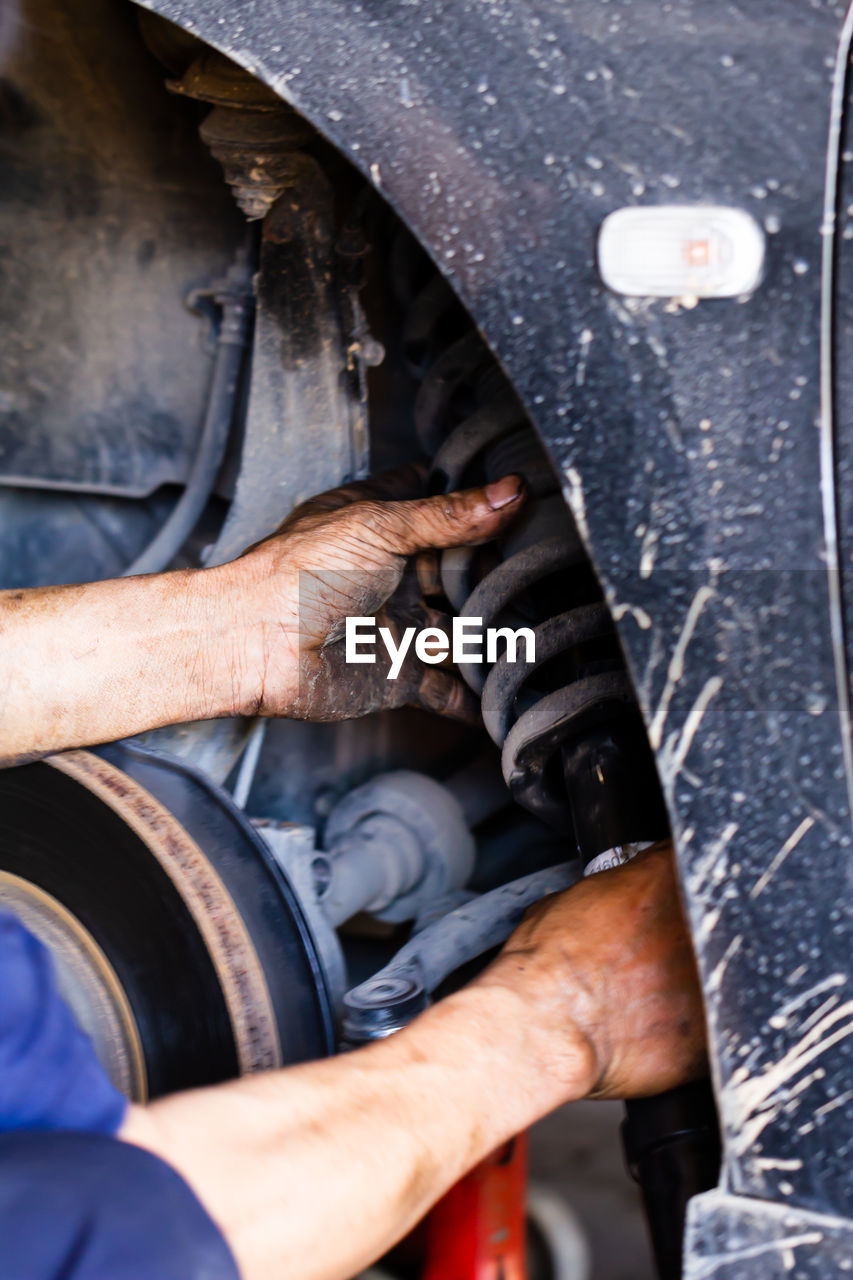 Car mechanic changing tire on the rim in service garage